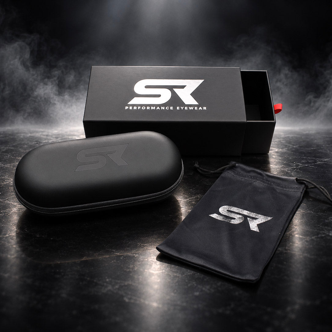 Black hard-shell eyewear case, black drawstring pouch, and black presentation box with a large white 'SR' logo and the words 'PERFORMANCE EYEWEAR' on a dark smoky studio background.