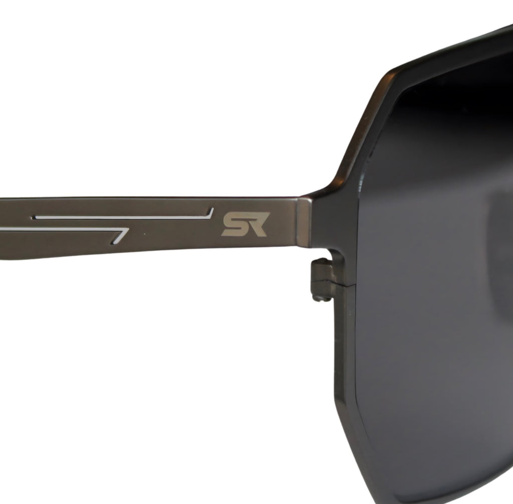 Close-up of SkyRift Vector sunglasses showing pure titanium gunmetal frame and engraved SR logo