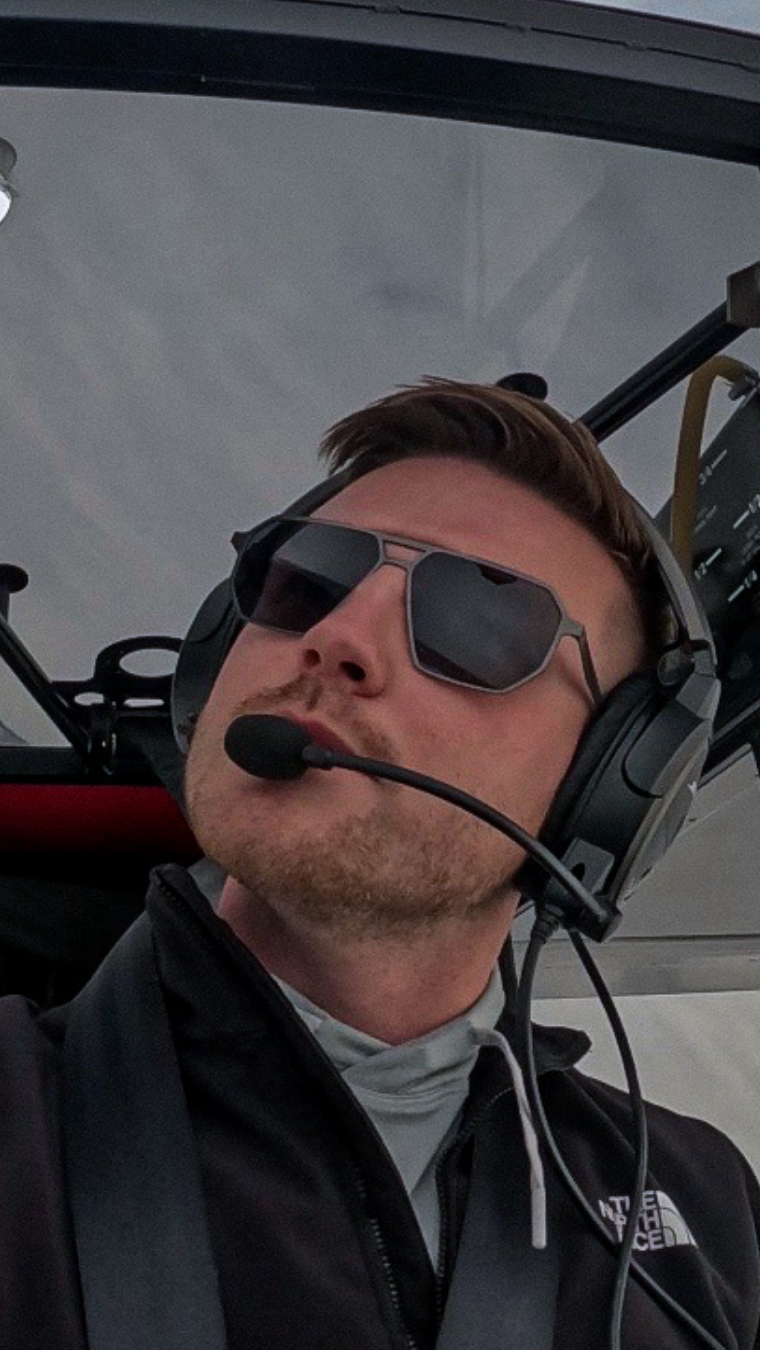 Pilot wearing SkyRift sunglasses in an aircraft cockpit, designed for clarity and performance